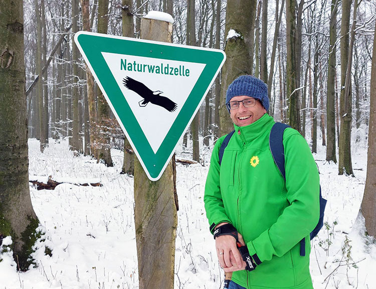 Ulli Möhl vor dem Schild Naturwaldzelle